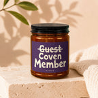 Amber jar candle, purple label with white text reading "Guest Coven Member".