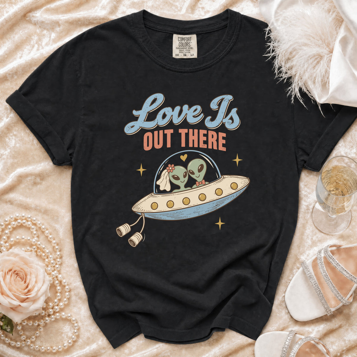 Black t-shirt with "Love Is Out There" text and aliens in a UFO graphic.