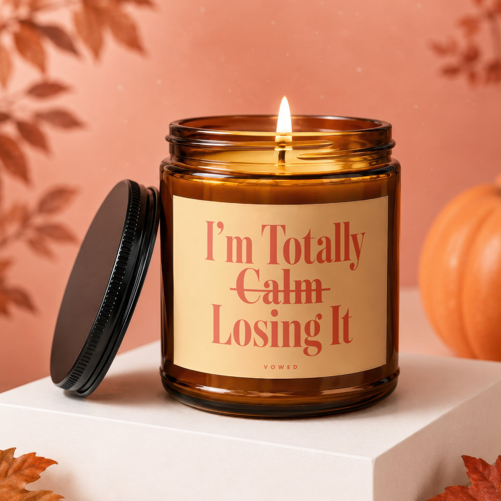 Amber candle with lit wick, black lid, says "I'm Totally Calm Losing It".