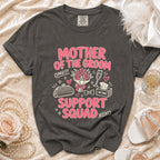 T-shirt with "Mother of the Groom Support Squad" graphic and wedding accessories.