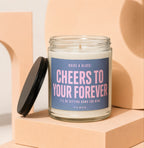 Candle with blue label reading "Cheers to Your Forever" and "Vowed."