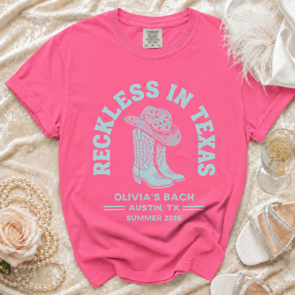 Pink t-shirt with "Reckless in Texas" and "Olivia's Bach Austin, TX Summer 2026" text.
