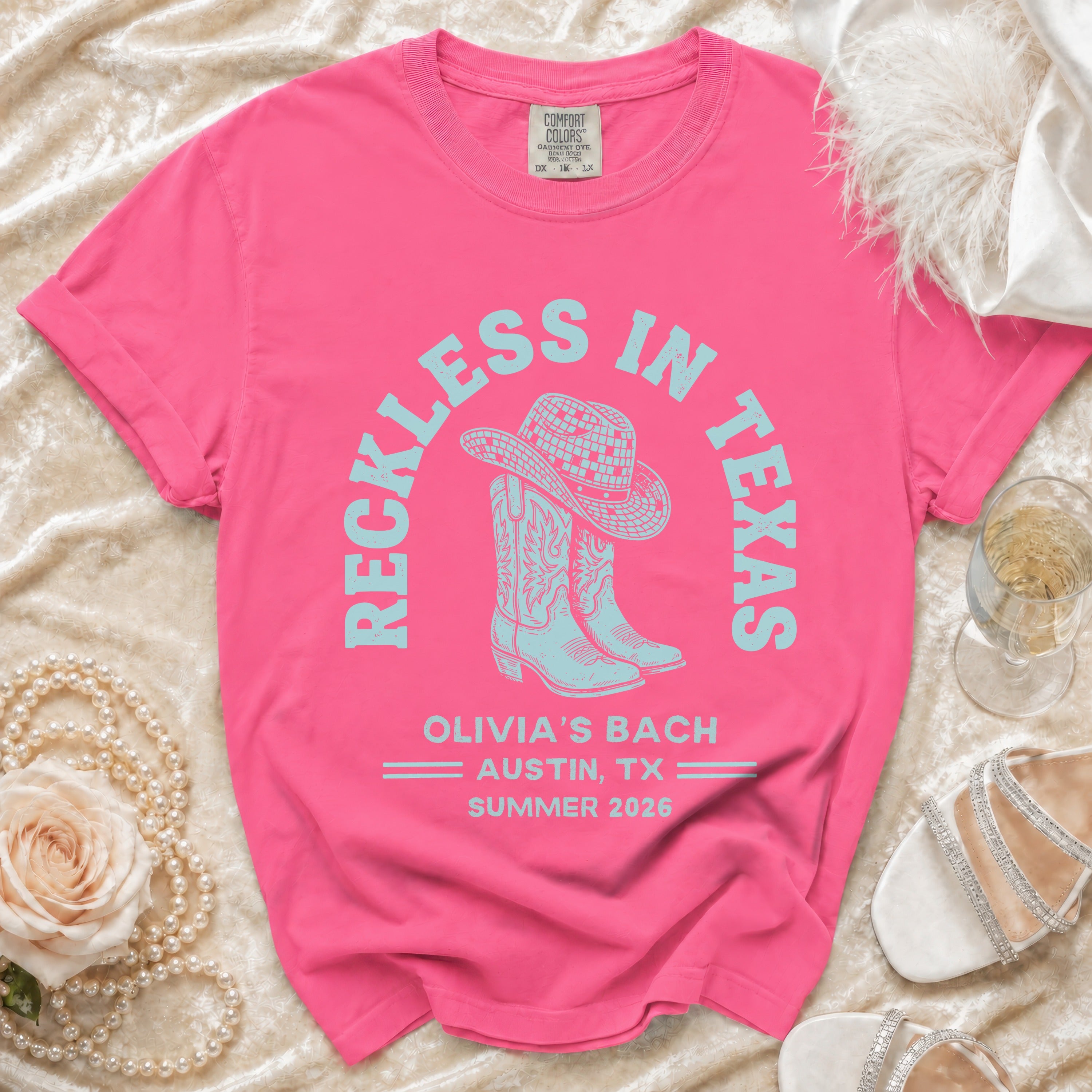Pink t-shirt with "Reckless in Texas" and "Olivia's Bach Austin, TX Summer 2026" text.