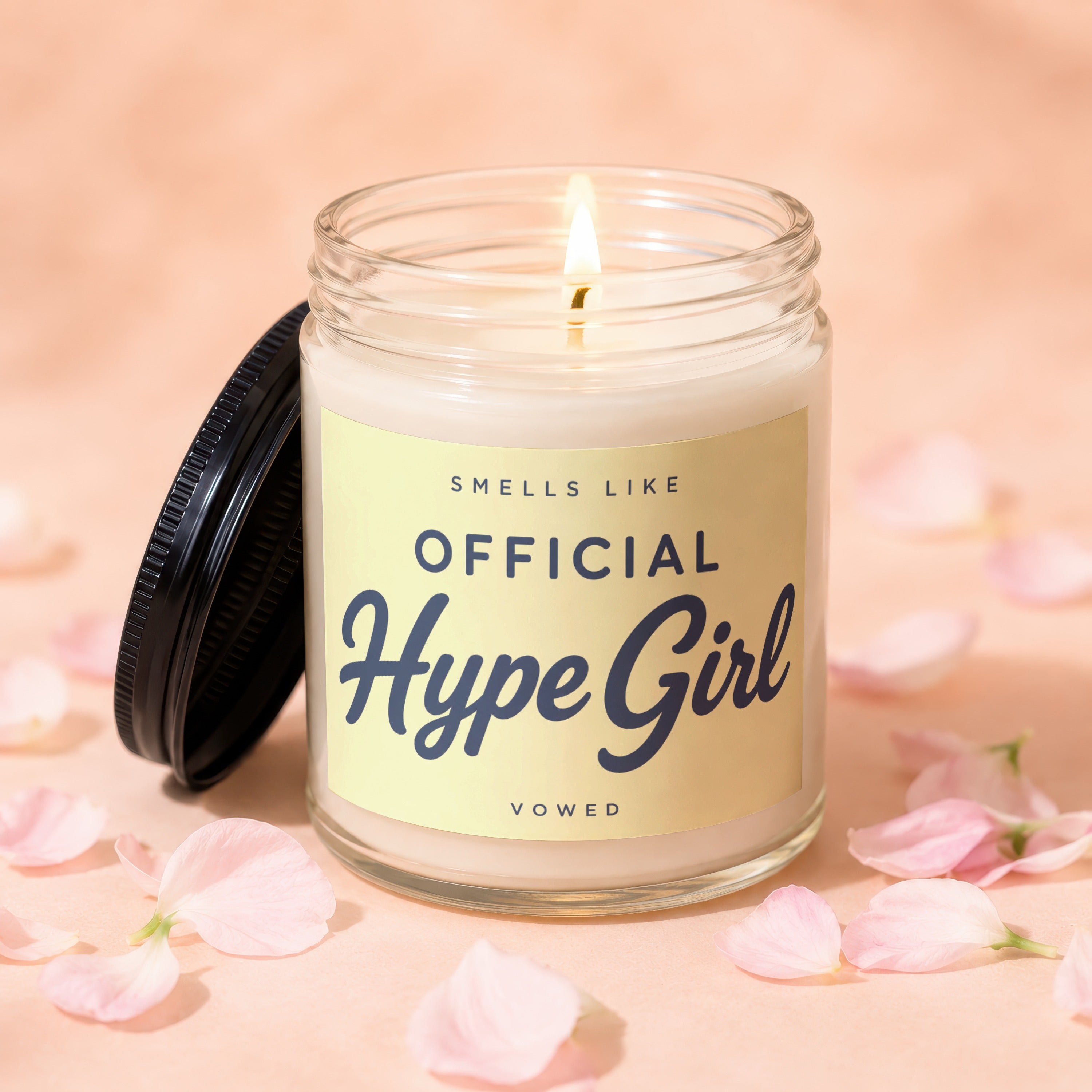 Glass candle with lit wick, reads "Smells Like Official Hype Girl"