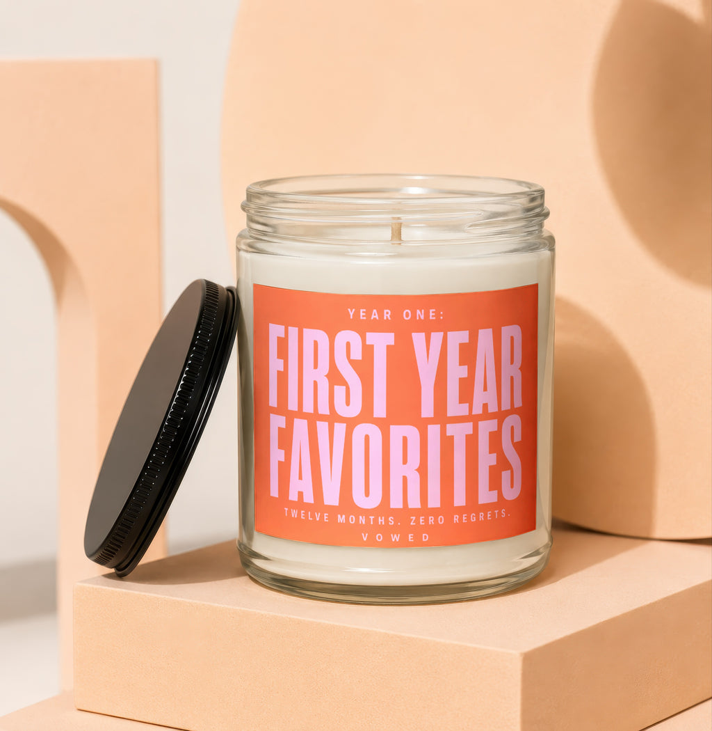 Glass candle with orange label reading "Year One: First Year Favorites".