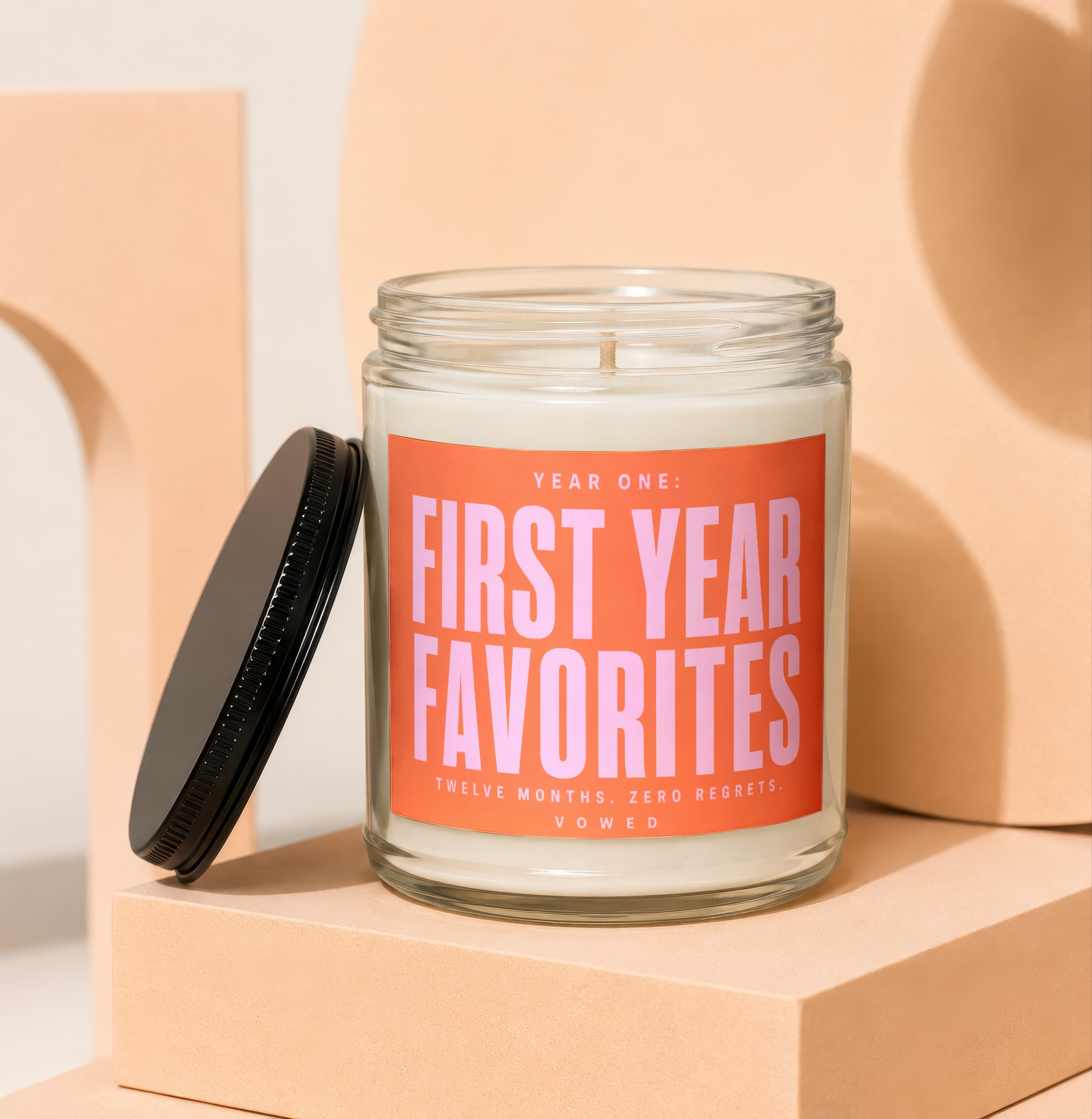 Glass candle with orange label reading "Year One: First Year Favorites".