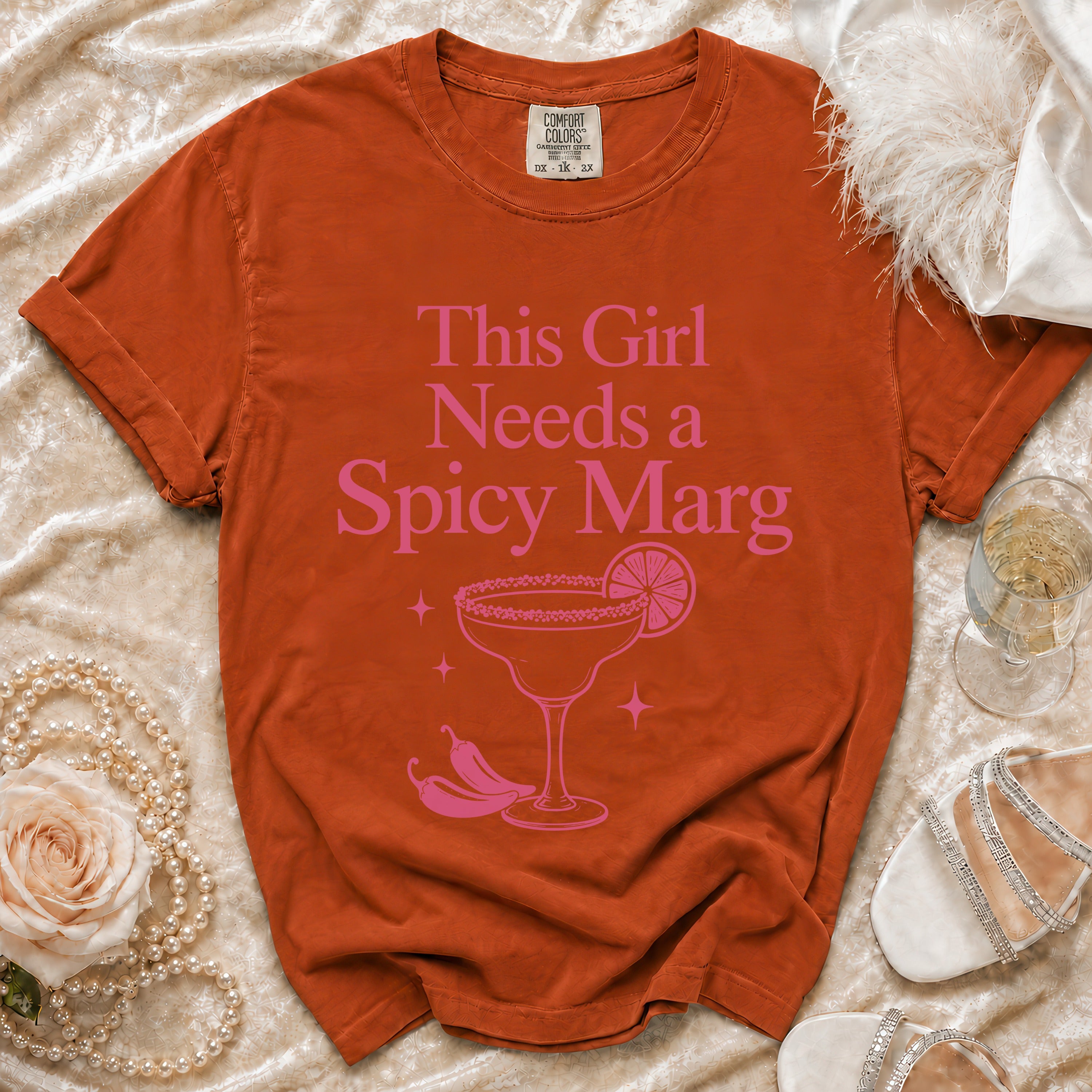 Orange t-shirt with pink text that says "This Girl Needs a Spicy Marg".