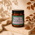 Amber candle with green label that says "SMELLS LIKE YOU'RE GETTING MARRIED VOWED".