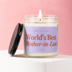 Candle with lit wick and label reading "Smells like World's Best Mother-in-Law".