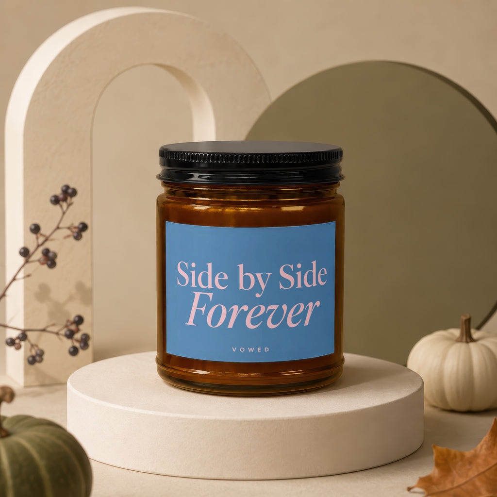 Glass candle with black lid, blue label reading "Side by Side Forever", on pedestal.
