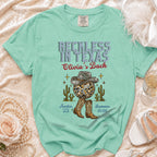 Mint green t-shirt with "Reckless in Texas Olivia's Bach" text, disco ball, cactus, and boots.