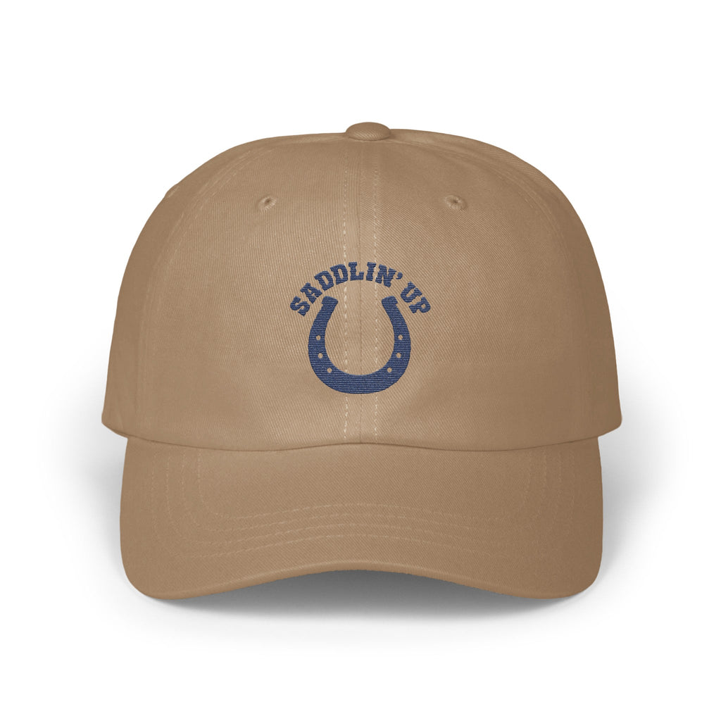 Tan baseball cap with embroidered blue horseshoe logo and the text SADDLIN UP.