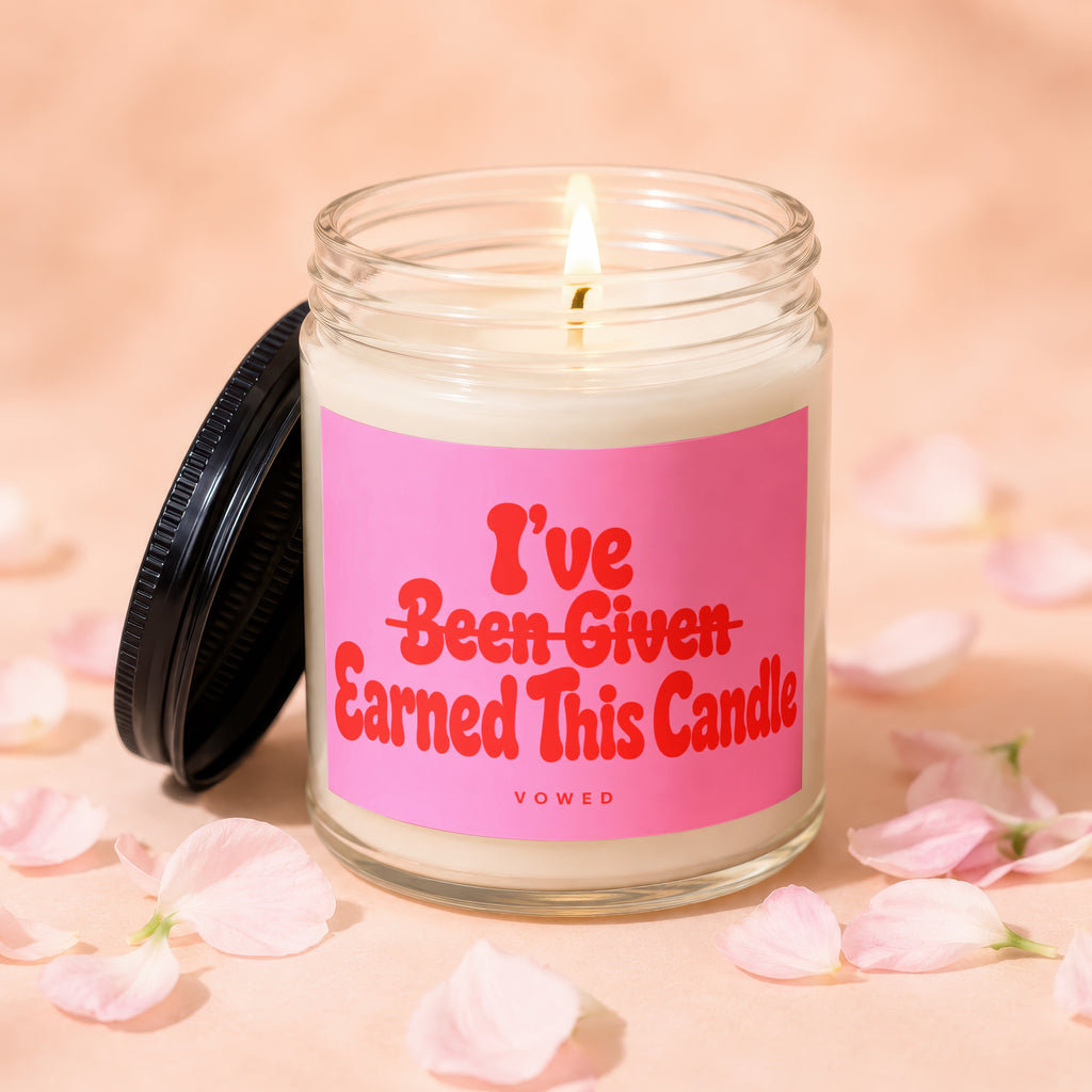 Lit candle in a jar with pink label that reads "I've Earned This Candle".