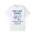 White t-shirt with "Her Last Rodeo" in blue, cowboy hat, boots, and rope.