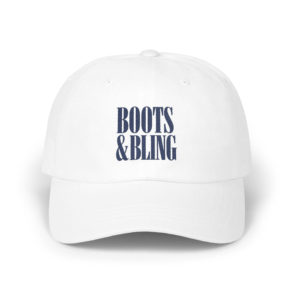 A white baseball cap featuring blue embroidered text that reads Boots and Bling centered on the front.