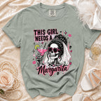 Green t-shirt with graphic of skeleton bride holding margarita and text "This girl needs a Margarita."