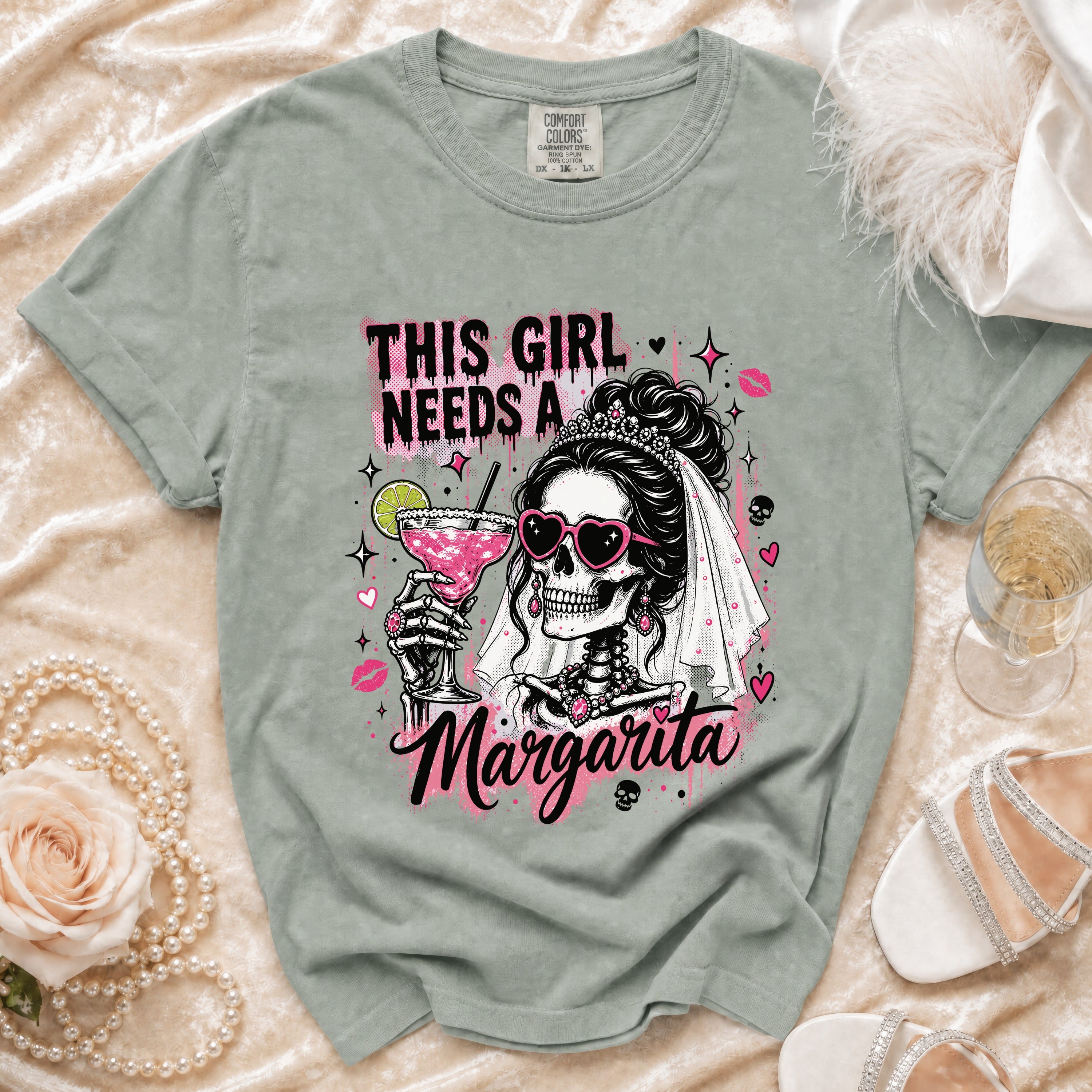 Green t-shirt with graphic of skeleton bride holding margarita and text "This girl needs a Margarita."
