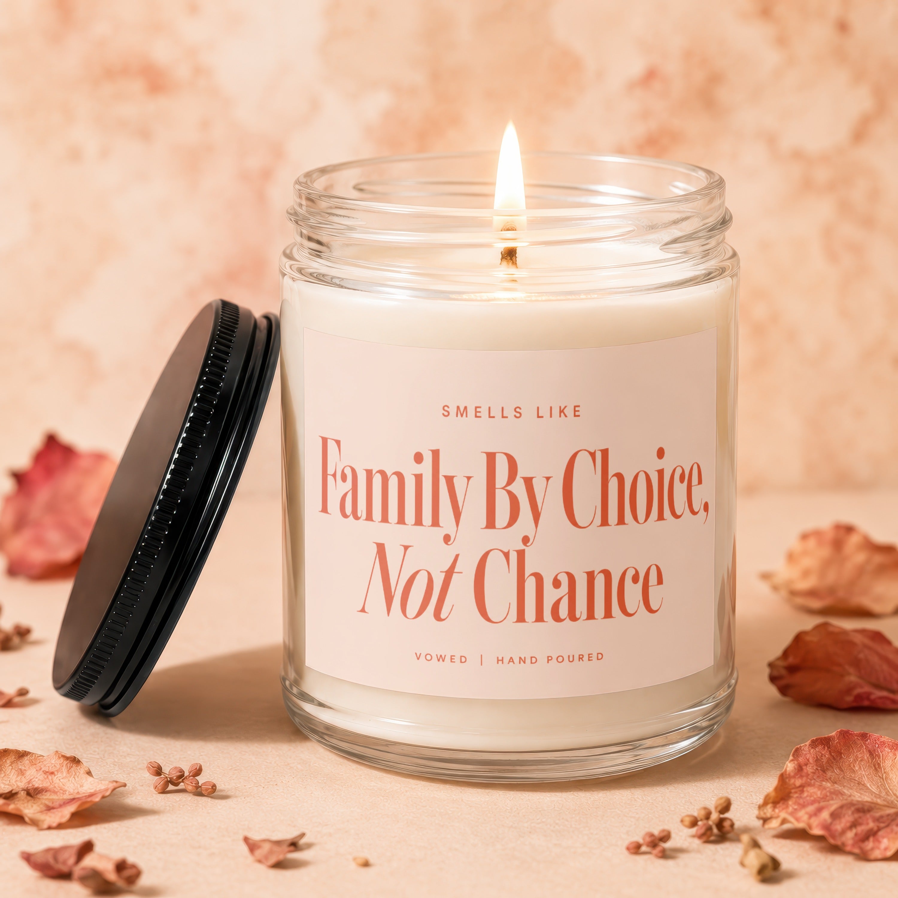 Glass jar candle with lit wick and "Family By Choice, Not Chance" text.