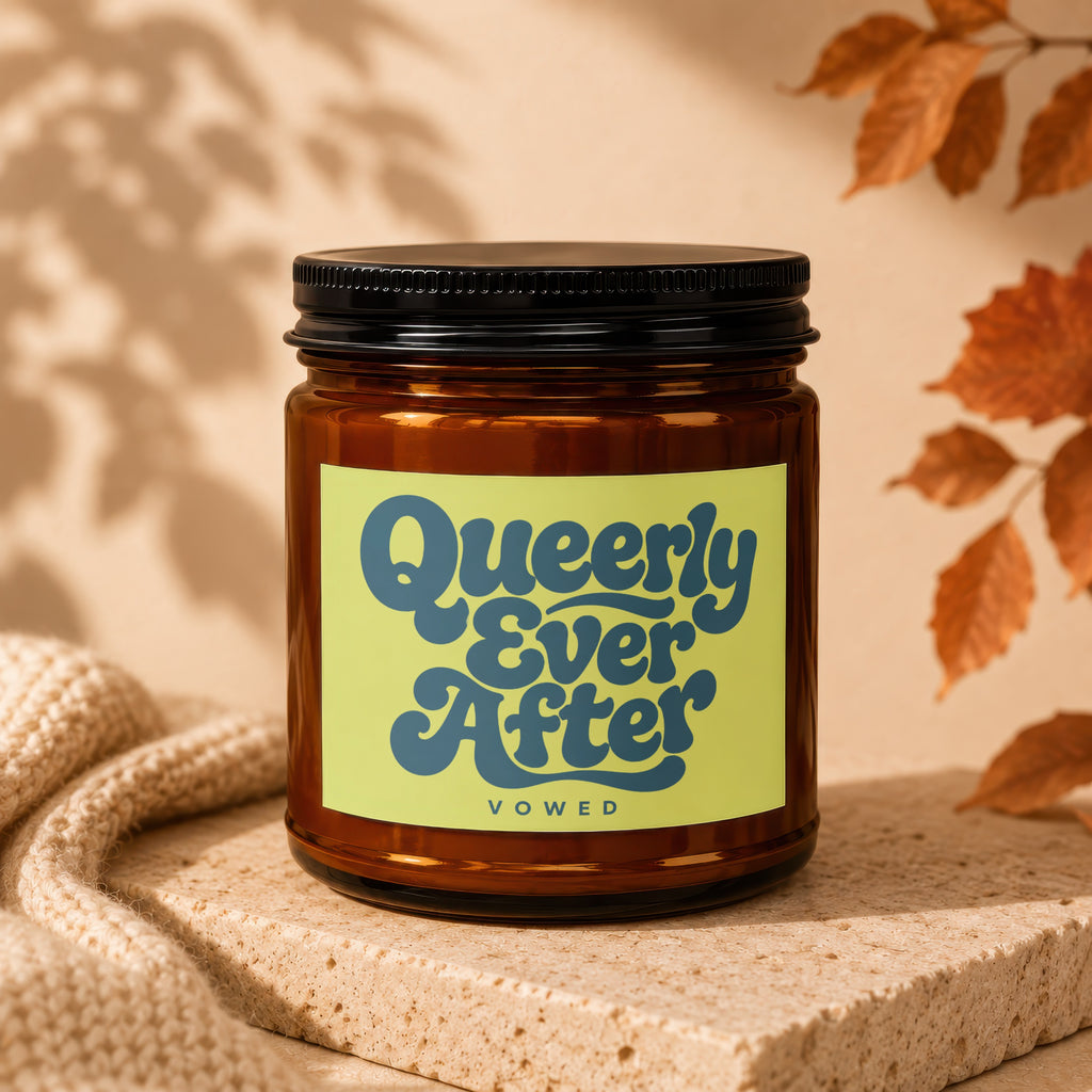 Amber candle in a jar with a "Queerly Ever After" label and "VOWED" text.