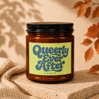 Amber candle in a jar with a "Queerly Ever After" label and "VOWED" text.