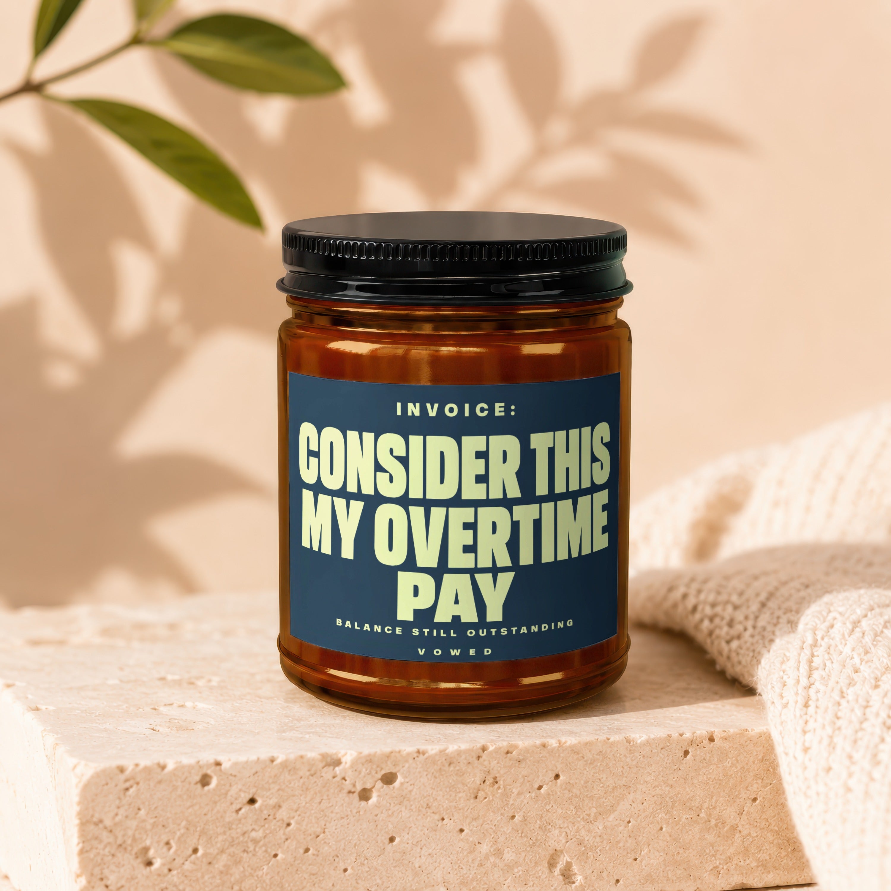 Jar with black lid, textured label reading "INVOICE: CONSIDER THIS MY OVERTIME PAY BALANCE STILL OUTSTANDING VOWED".