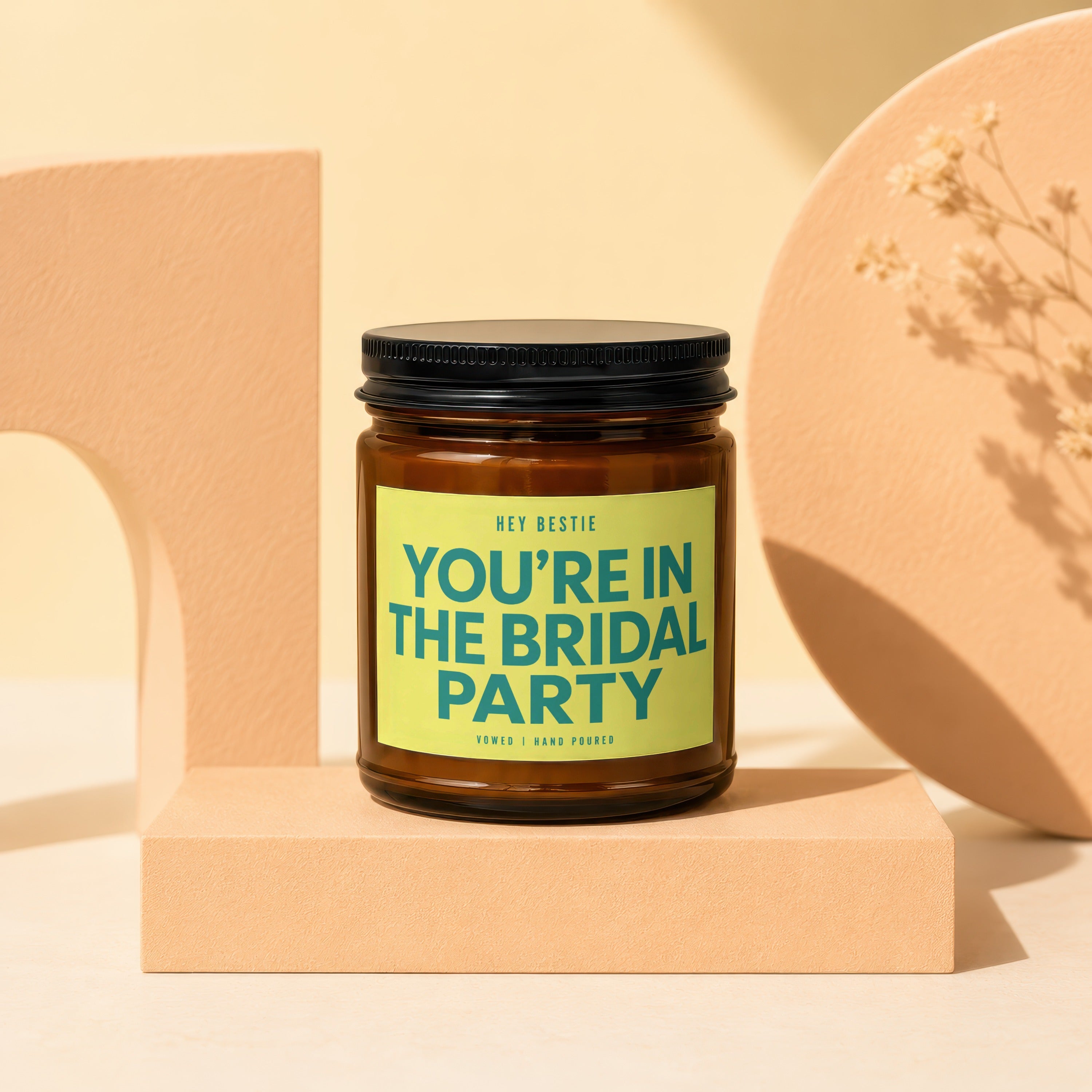 Brown jar candle with black lid, light green label saying "You're in the Bridal Party".
