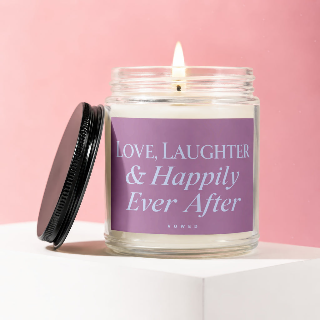 Candle with lit wick on a white stand, with text "Love, Laughter & Happily Ever After".