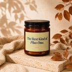 Amber jar candle with black lid, labeled "The Best Kind of Plus One."
