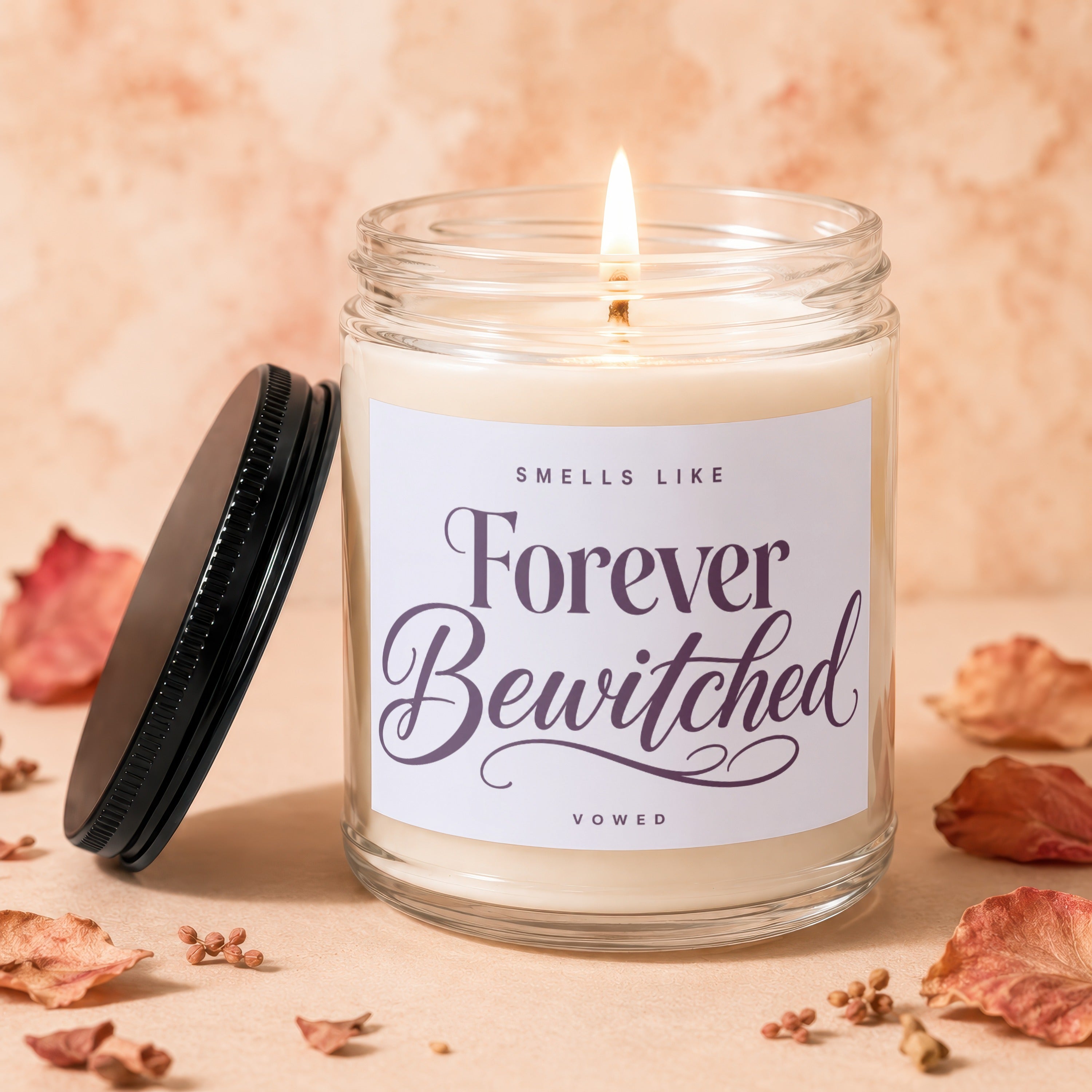 Glass jar candle with lit wick, "Forever Bewitched" label, and black lid.