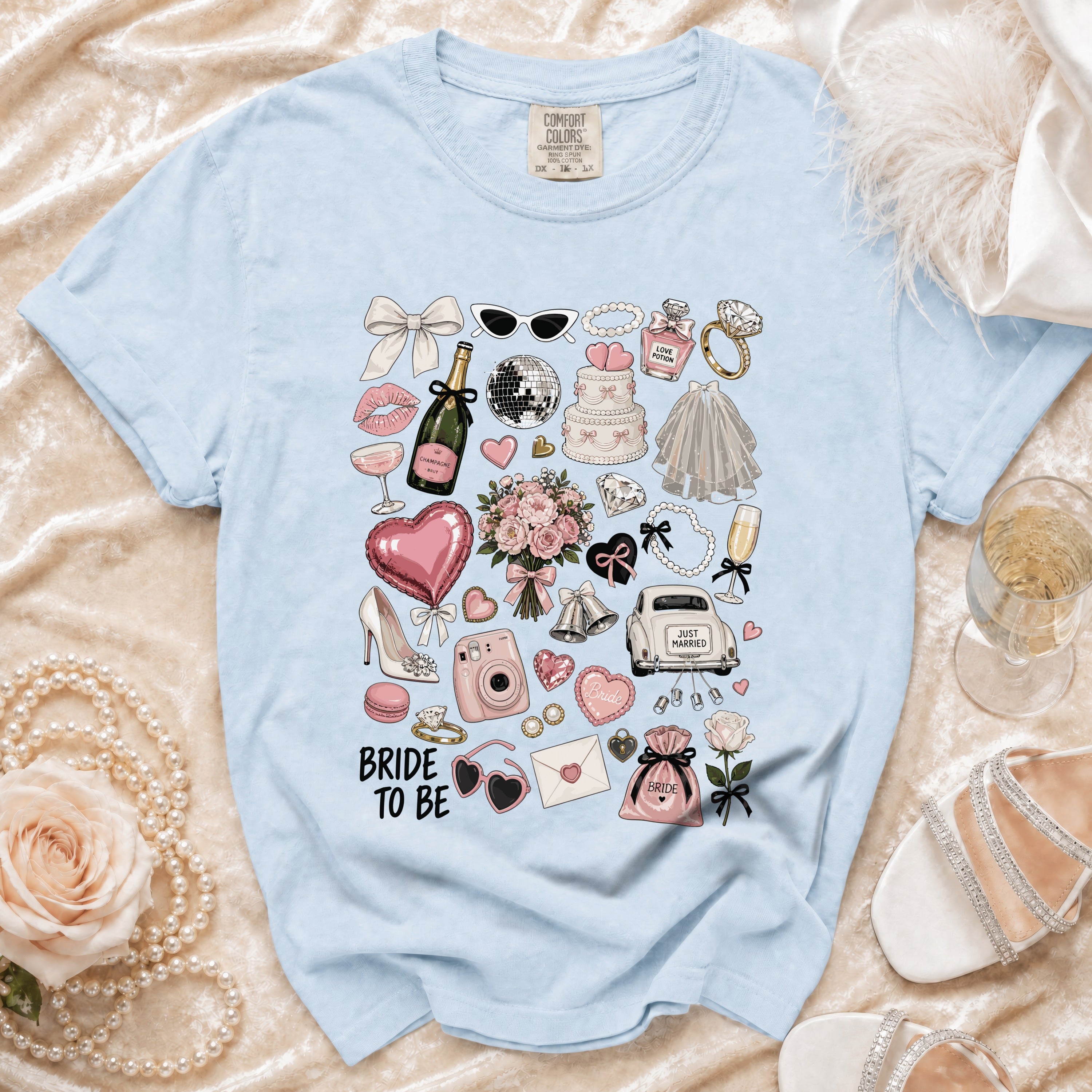 Light blue t-shirt with "Bride to Be" text and wedding-themed illustrations.
