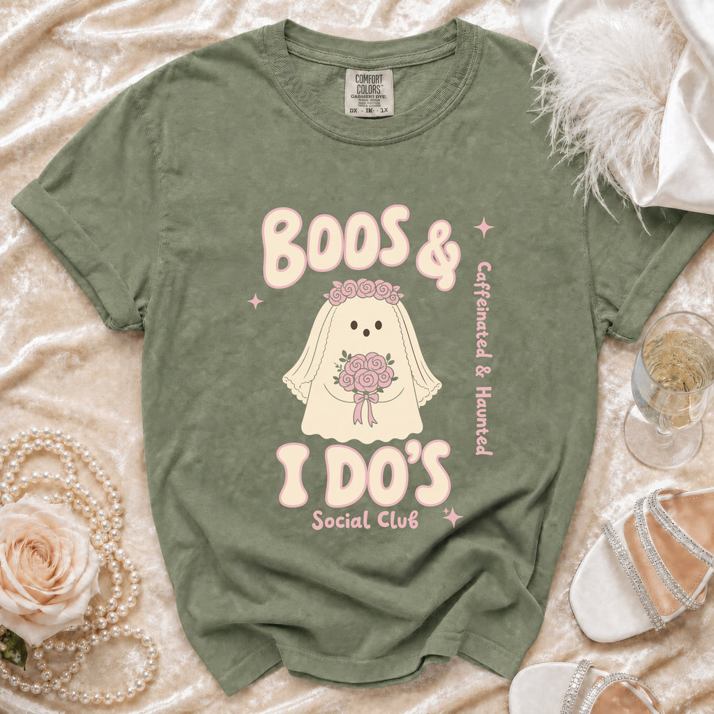 Green t-shirt with ghost bride graphic saying "Boos & I Do's Social Club" and "Caffeinated & Haunted".