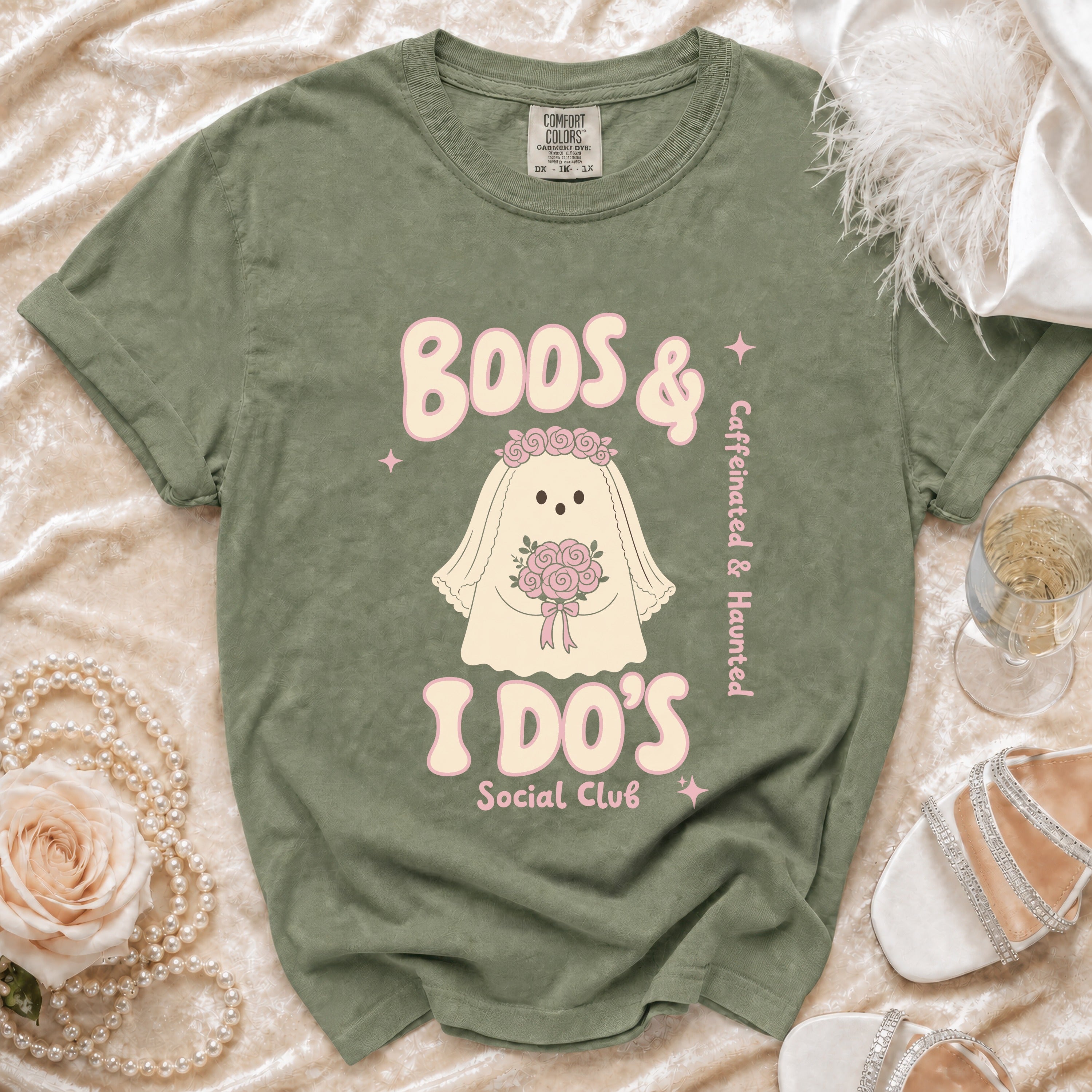 Green t-shirt with ghost bride graphic saying "Boos & I Do's Social Club" and "Caffeinated & Haunted".