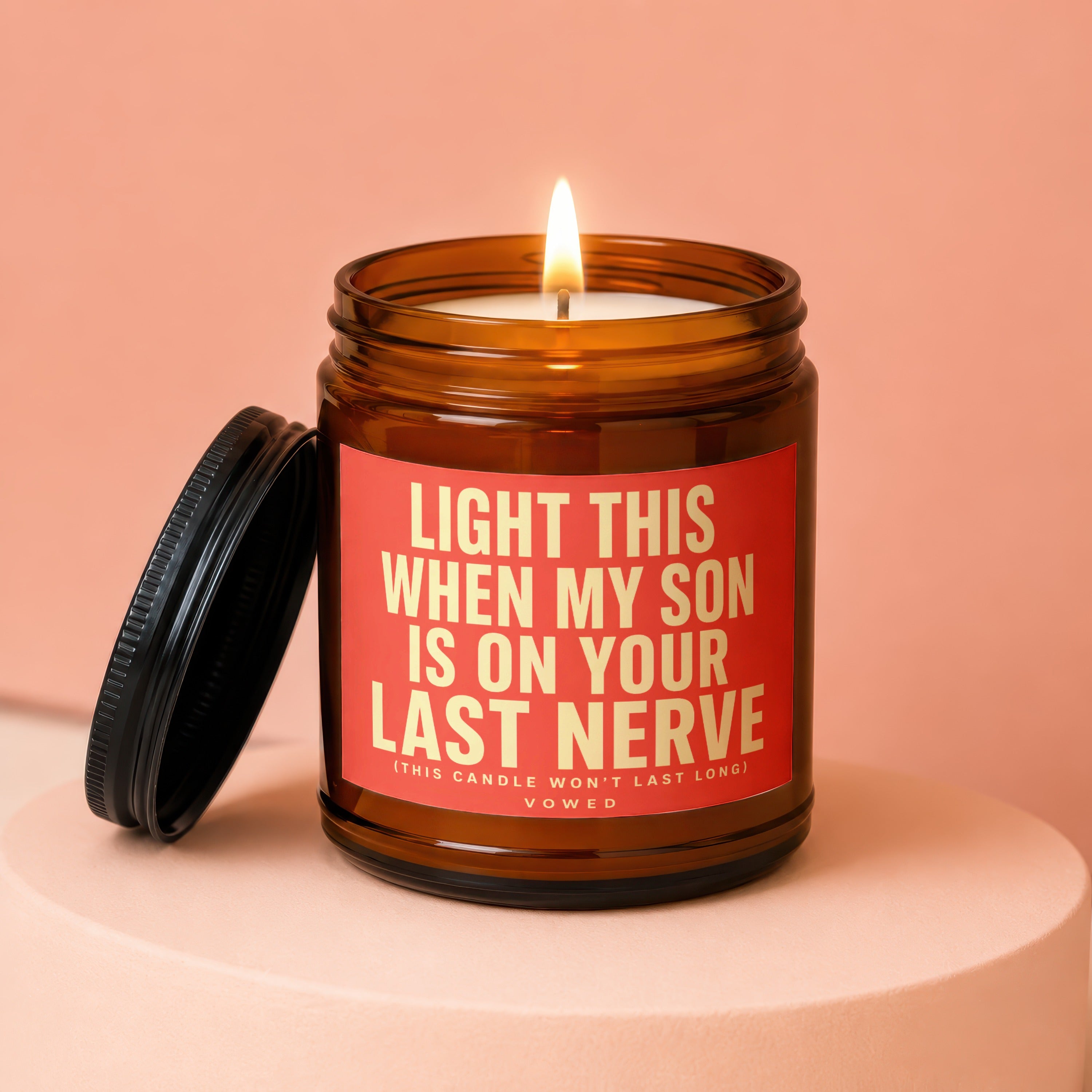 Amber jar candle with lit wick and lid off, reads "Light this when my son is on your last nerve".