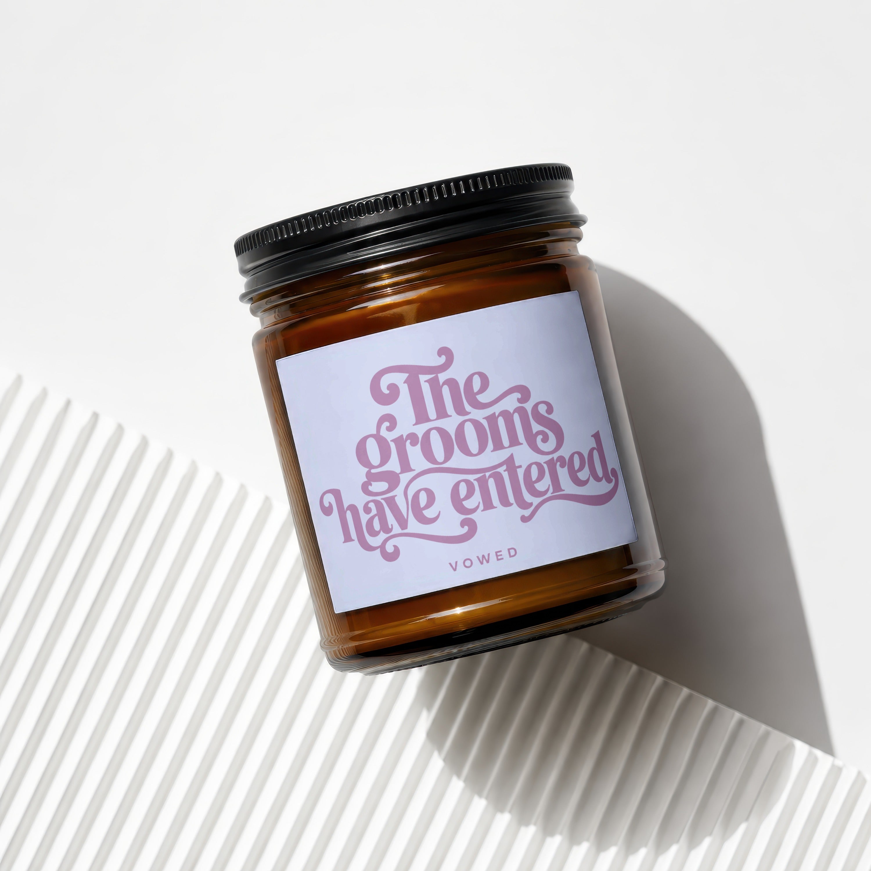 Amber jar candle with lavender label reading "The grooms have entered" and "VOWED".