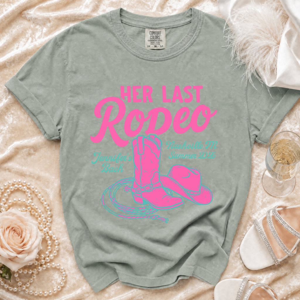 Pink cowboy boots, hat, and lasso on a vintage-style t-shirt with "Her Last Rodeo" text.
