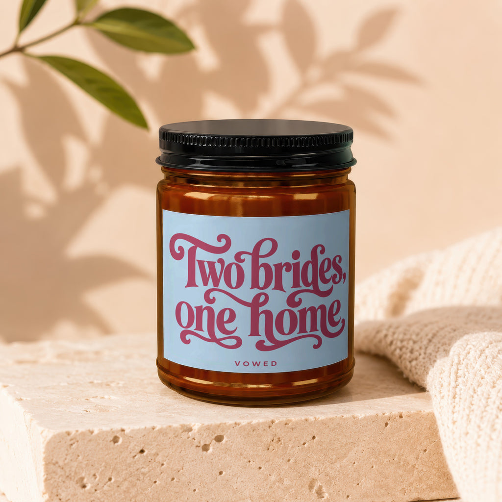 Candle in amber jar with label reading "Two brides, one home" and "vowed".
