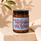 Candle in amber jar with label reading "Two brides, one home" and "vowed".