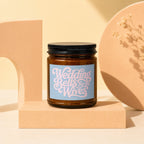 Amber glass candle with blue label reading "Wedding Bells for the Wives VOWED".