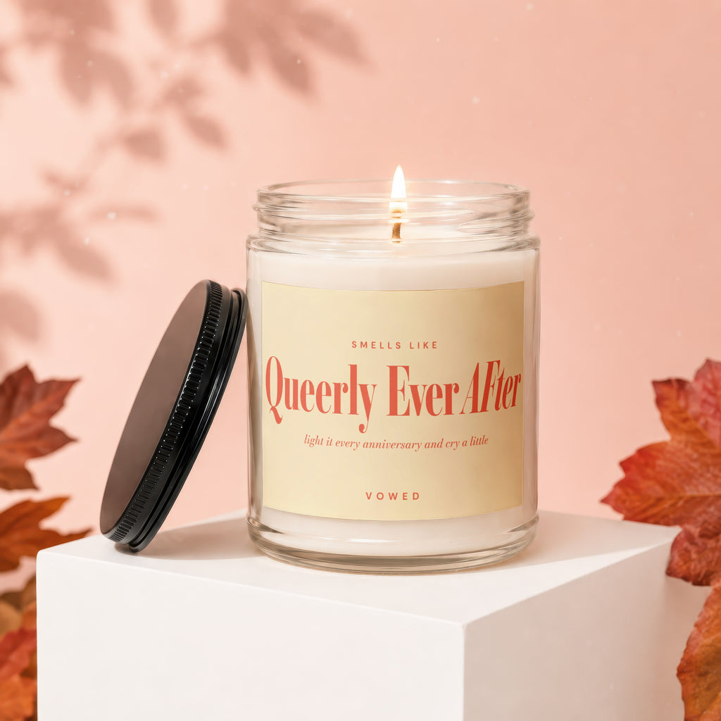 Glass jar candle with "Queerly Ever After" label and lit wick.