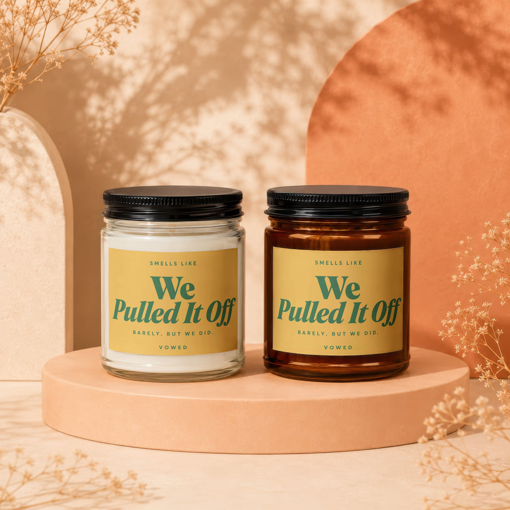 Two candles in jars with labels saying "We Pulled It Off".
