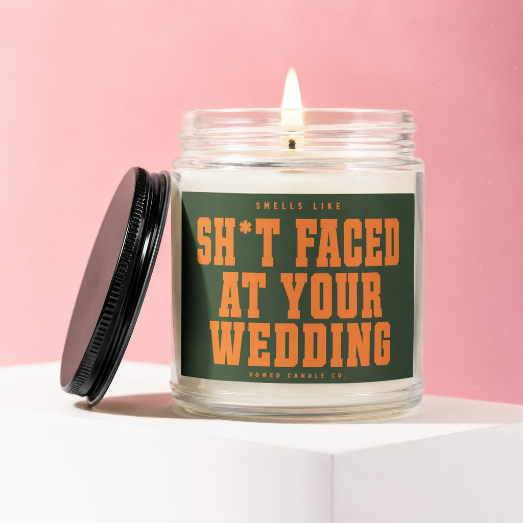 Burning candle in a jar with "Sh*t Faced At Your Wedding" text.