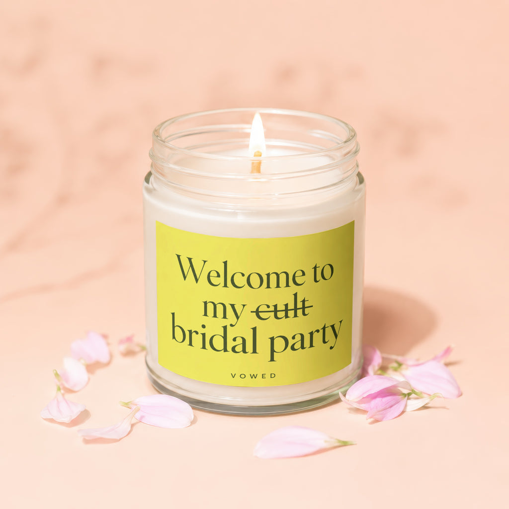 Lit candle with text "Welcome to my cult bridal party" on a light green label.
