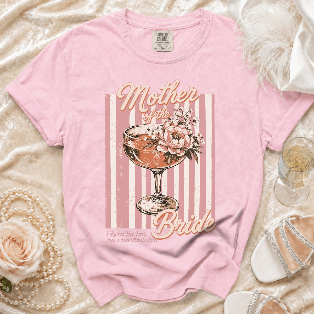 Pink t-shirt with "Mother of the Bride" text, cocktail glass, and flowers graphic.