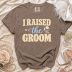 Brown t-shirt with "I RAISED the GROOM" text and floral graphic.
