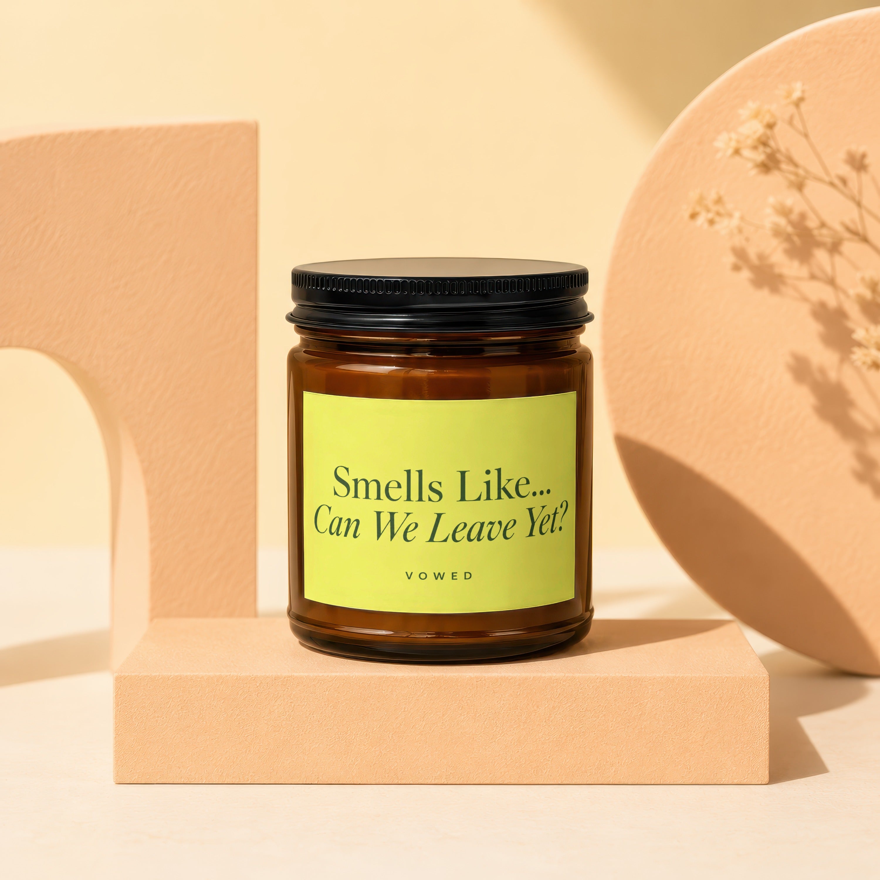 Amber candle with black lid, yellow label reads "Smells Like... Can We Leave Yet? VOWED".