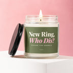 Candle with label "New Ring, Who Dis? Excuse the Sparkle" on pink background.