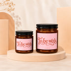 Two amber glass candles with pink labels reading "To-be-weds" and "Vowed."