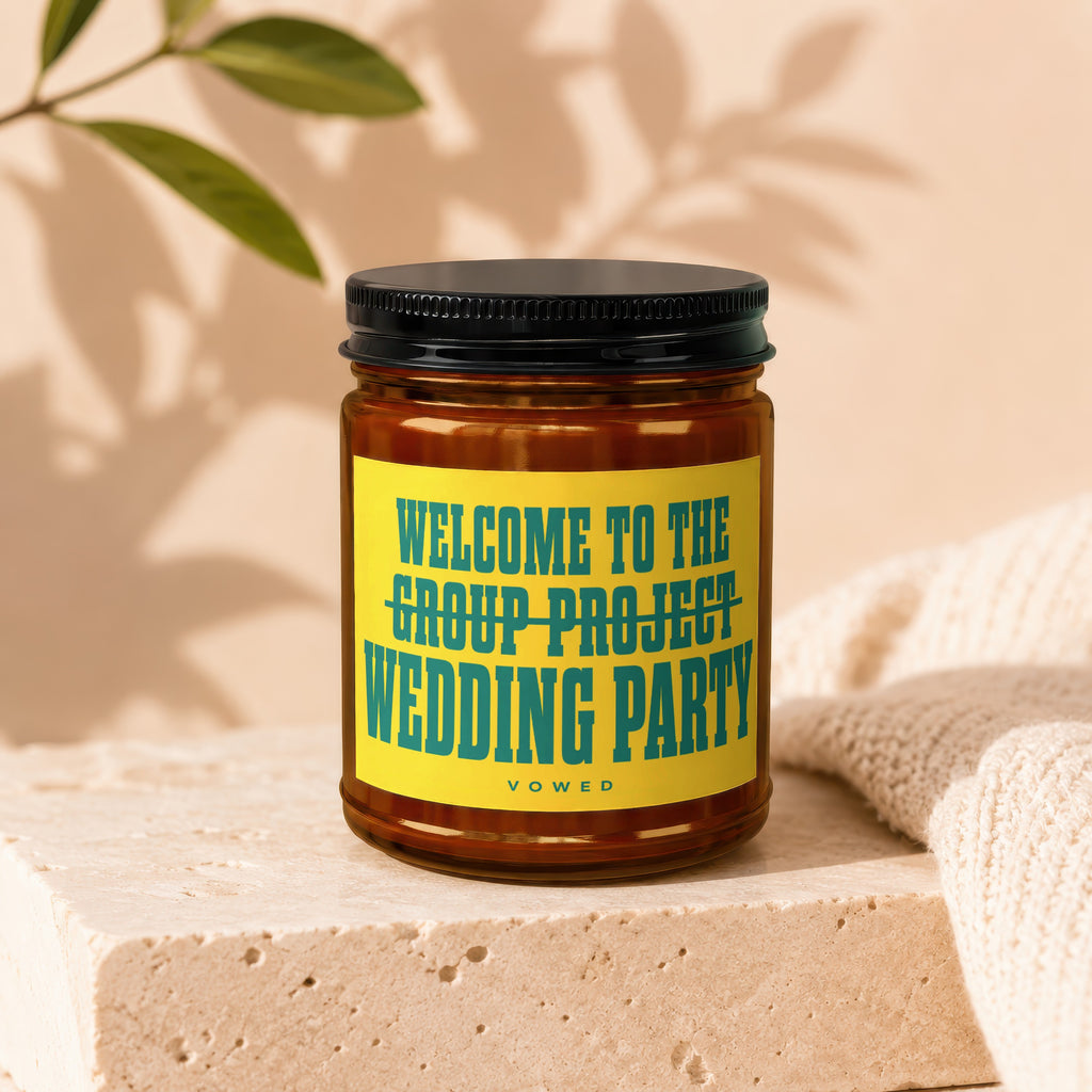Amber jar candle with yellow label reading "Welcome to the Group Project Wedding Party"