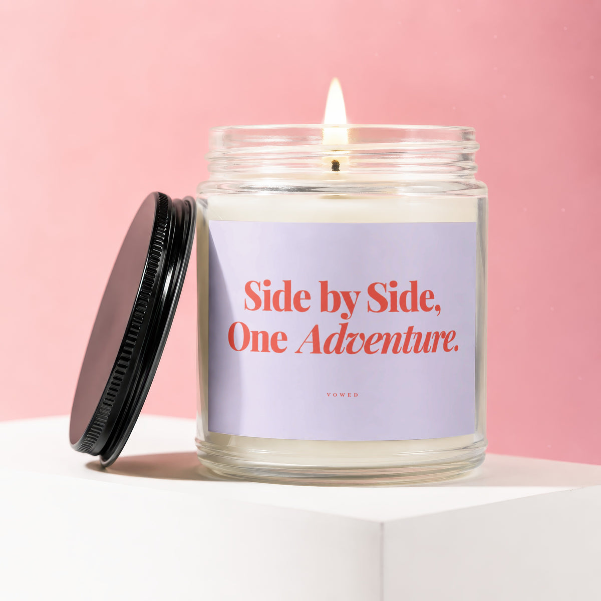 Candle with text "Side by Side, One Adventure" on a light purple label.