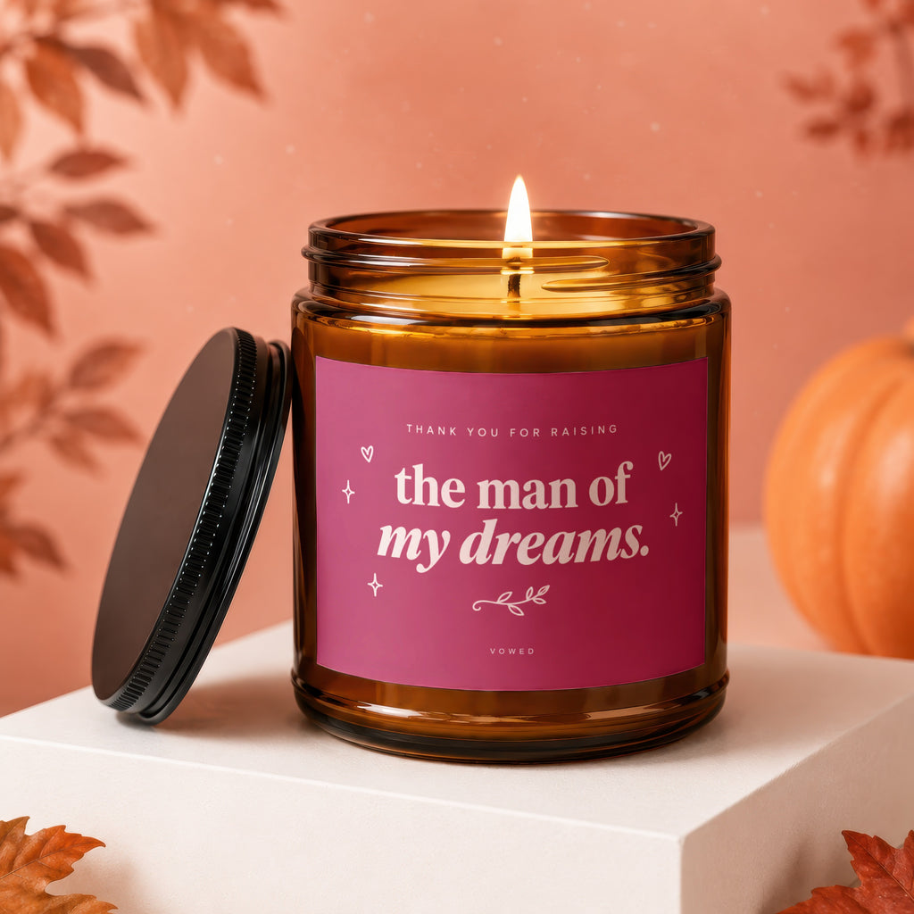 Amber candle with burning wick, lid off. Label reads "thank you for raising the man of my dreams. VOWED."